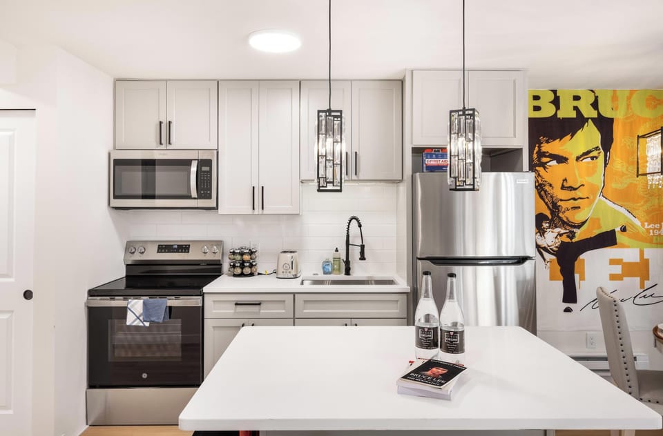 Dine in style with a beautiful crystal chandelier above, accompanied by iconic Bruce Lee wall art for a unique dining experience.