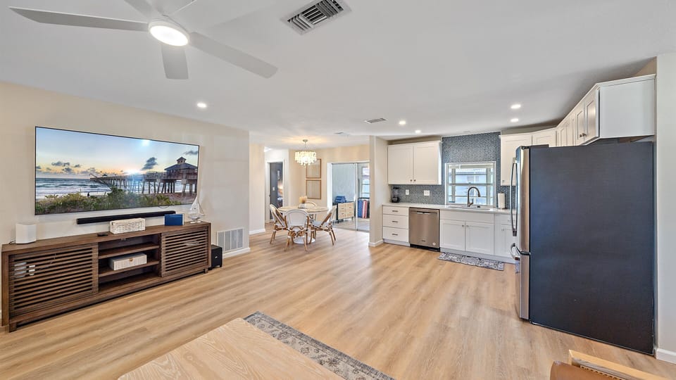 The expansive, airy main living area showcases beautiful coastal design and modern amenities, connecting the fully-equipped kitchen and living room for easy family entertaining.