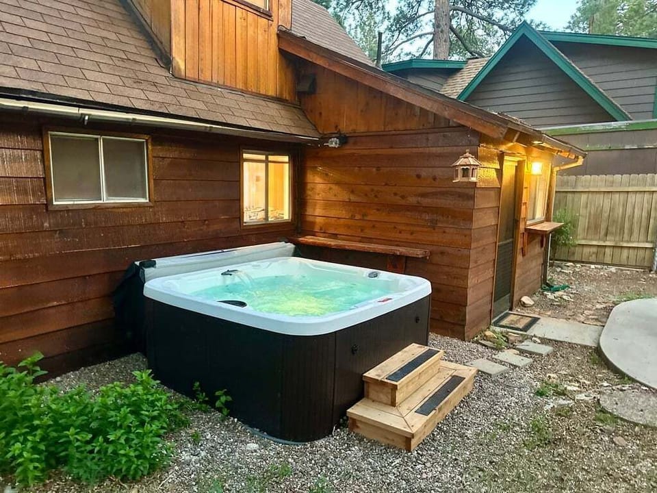 Private outdoor hot tub, surrounded by tall pines, perfect for relaxing under the trees after a day of adventure—enjoy peaceful forest views, fresh air, and a truly rejuvenating stay.