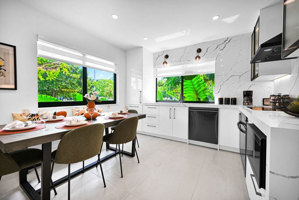 Bright kitchen and dining area with lush greenery and modern finishes.