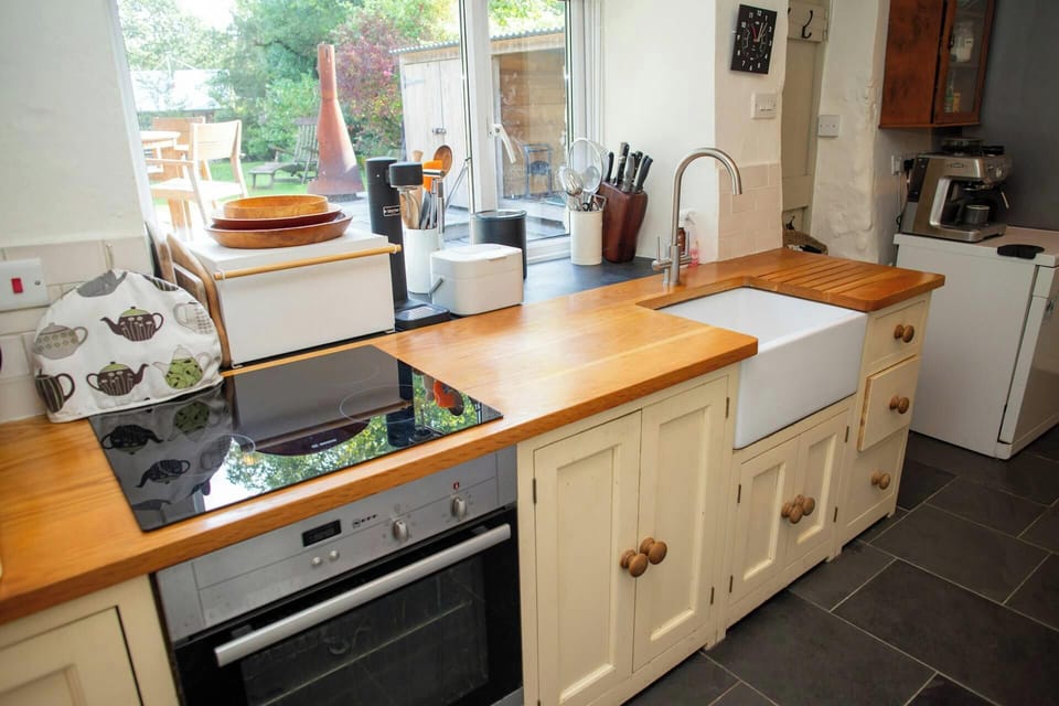 Kitchen with electric hob and oven. Wooden worktops and Belfast sinks