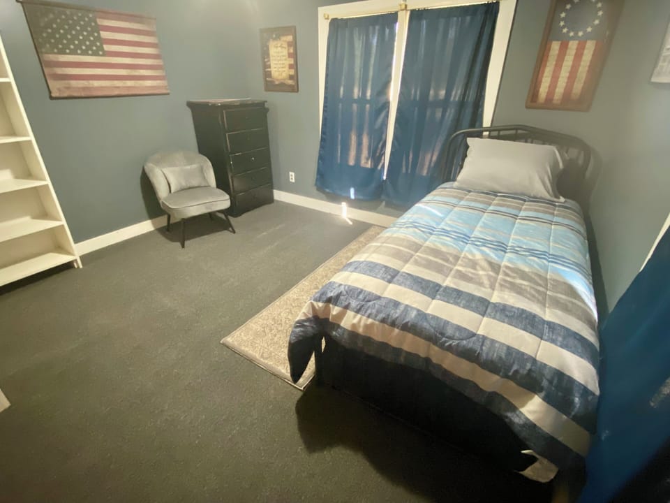 Bedroom 3 has a twin size bed, a large bookcase, medium sized closet & a chair. 