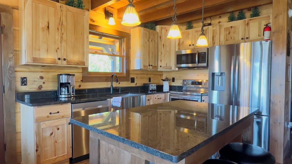 Fully equipped kitchen with island and bar stools for extra seating. 