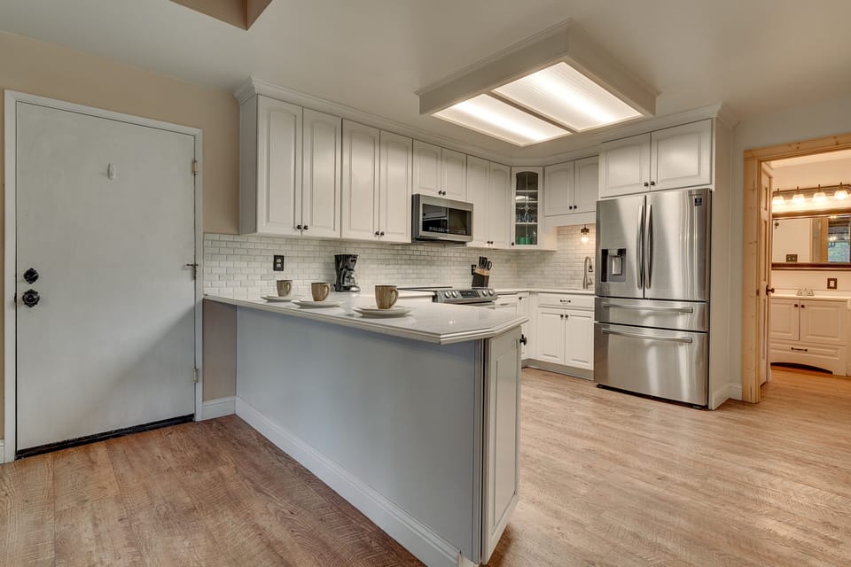 - Modern kitchen with stainless steel appliances and white cabinetry  
- Spacious countertops with breakfast bar and seating for three  
- Fully stocked for family cooking and extended stays