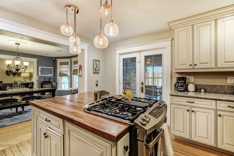 Charming kitchen with a central island, modern appliances, and French doors leading to the outdoor space, perfect for preparing meals and entertaining.