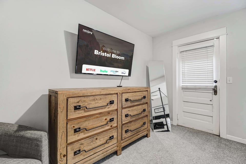 Bright and modern bedroom featuring a flat-screen TV and ample dresser space for a comfortable, organized stay.