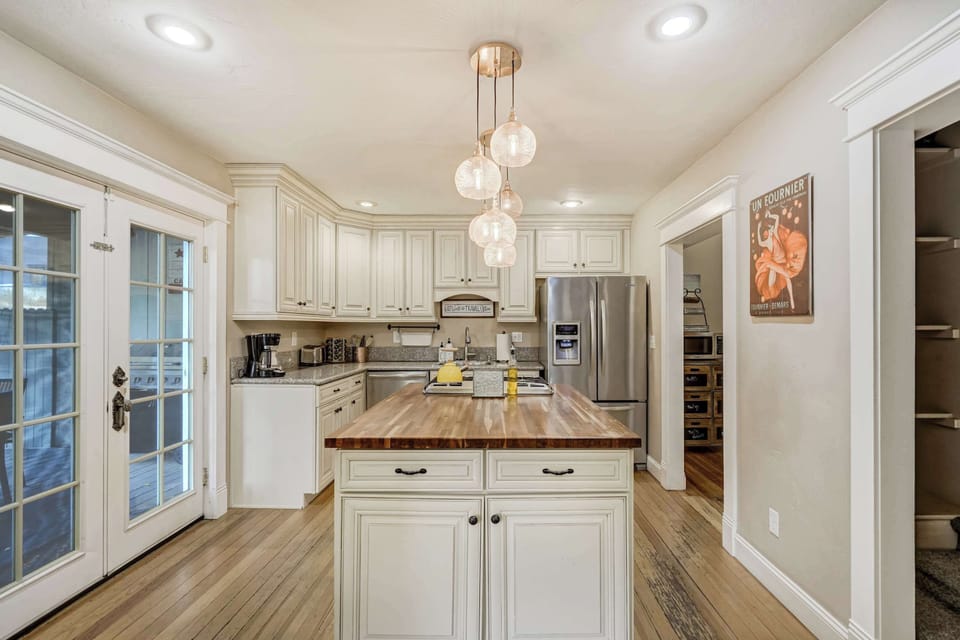 Spacious kitchen with sleek stainless steel appliances, a butcher block island, and warm lighting, creating the perfect space for cooking and entertaining.