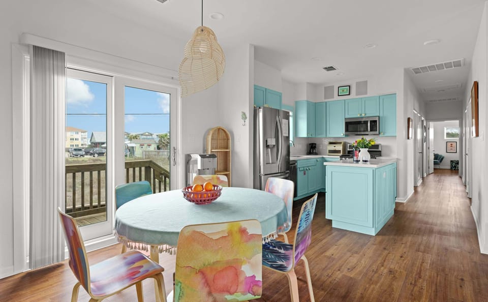 Unit 2122A — Kitchen alternate view with turquoise island, hallway to bedrooms, and recessed lighting