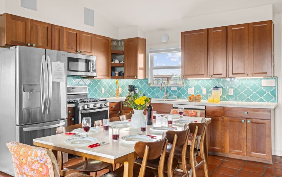 Unit 2120 — Kitchen with turquoise arabesque tile backsplash, wood cabinetry, and gas range