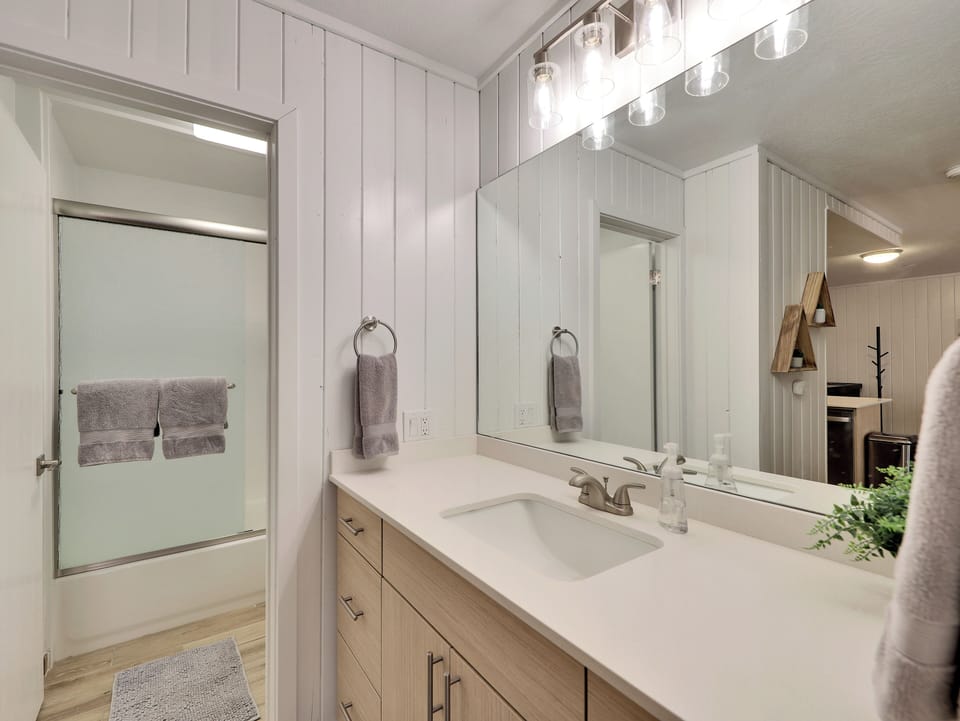 Upgraded and newly remodeled bathroom with shower/tub combo, sink, storage and upgraded lighting