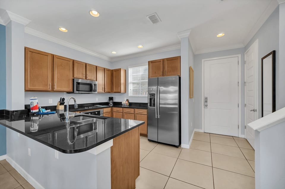 Spacious, well appointed kitchen with stainless appliances and solid surface counters