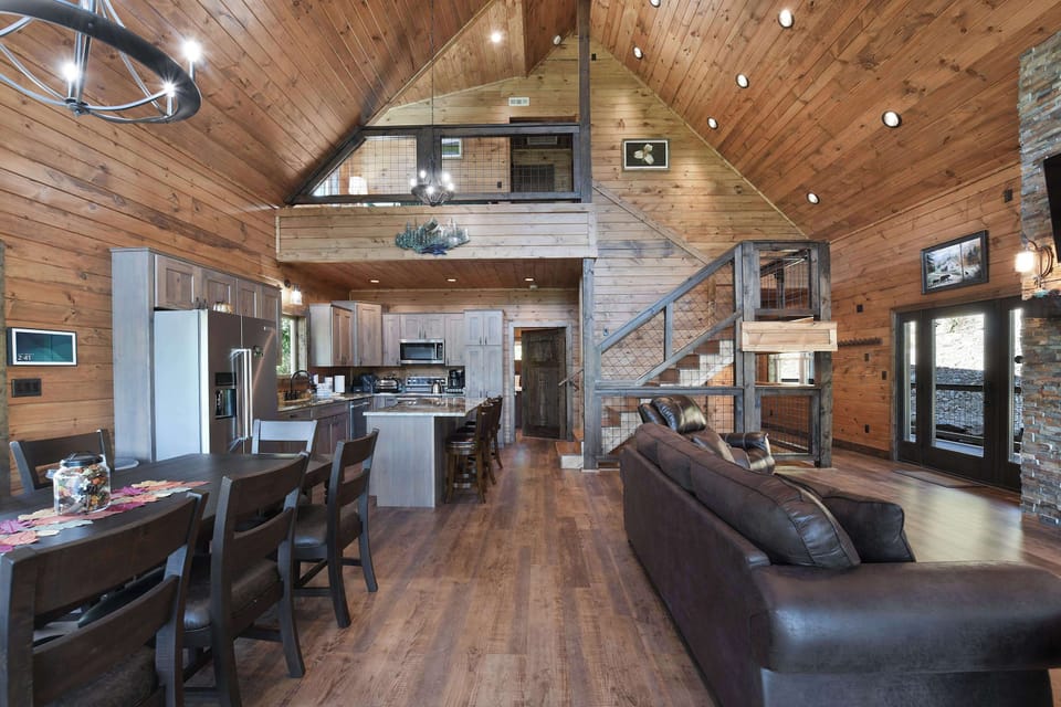 Spacious rustic living area with vaulted ceilings and an open kitchen layout.