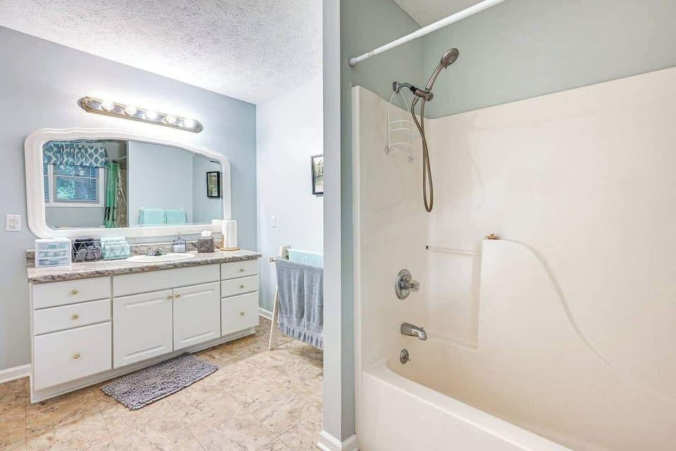 Bright and clean 1st-floor full bathroom with a shower/tub combo, oversized vanity, and complimentary toiletries.