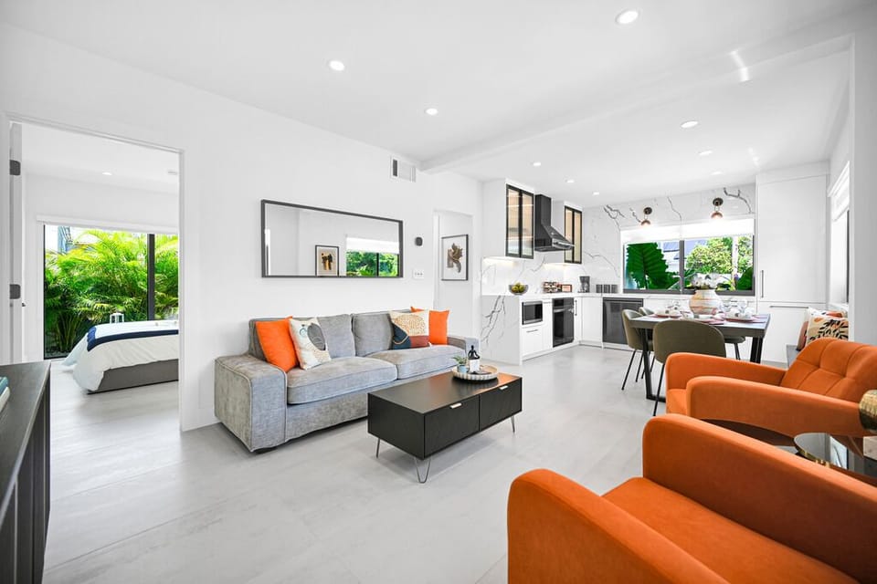 "Bright living area with bold orange chairs and modern accents."