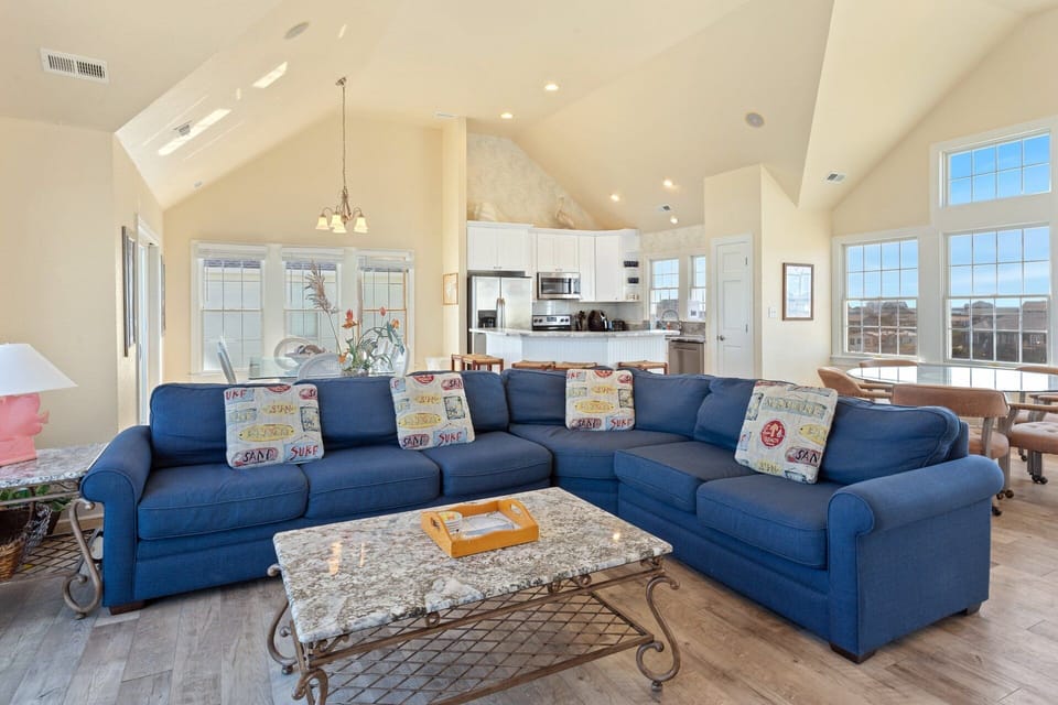 Relax in the spacious Living Area with cathedral ceilings and a flat-screen TV that is perfect for family movie night or catching up on your favorite shows after a day at the beach.