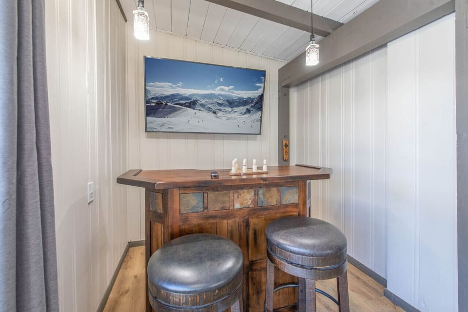 Intimate bar nook w/ high-top table & stools, perfect for a quiet drink.