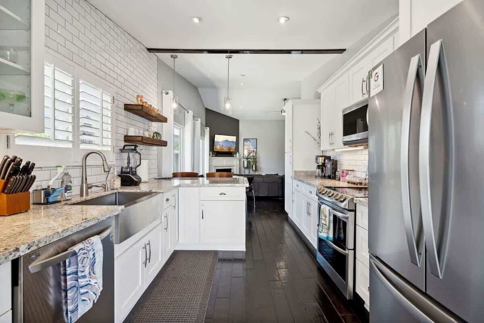 The fully equipped modern kitchen is stocked with all culinary essentials and stainless-steel appliances complete with island bar seating.