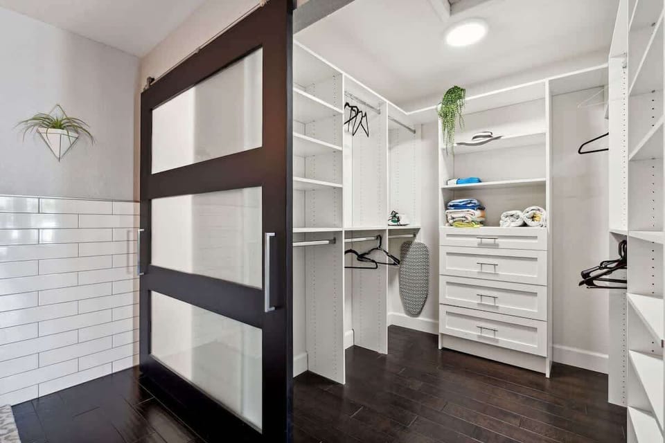 Primary bedroom with California King bed, smart TV, large walk-in closet, en-suite bathroom, and private outdoor patio & pool access.