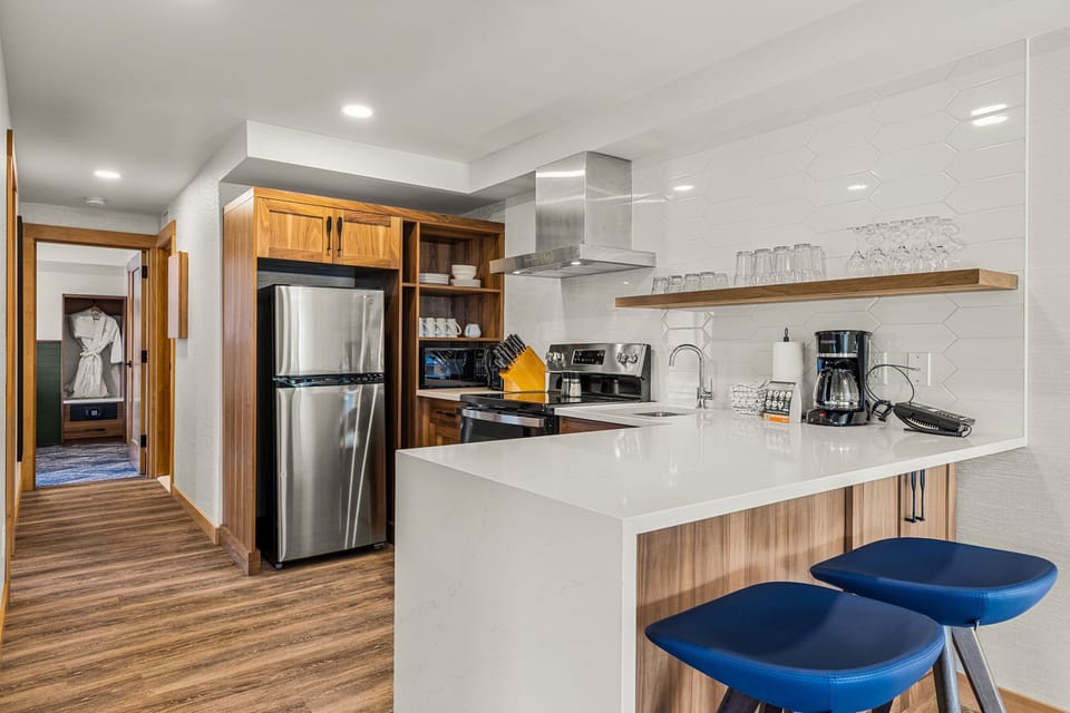Fully equipped kitchen with sleek appliances and a breakfast bar, perfect for cooking and dining in.