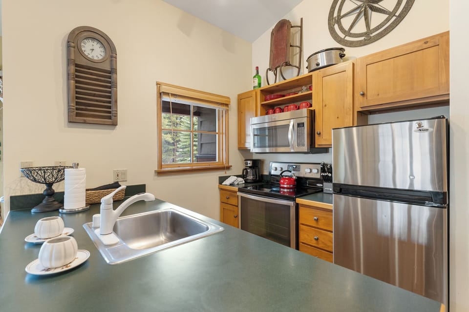 Your fully equipped kitchen awaits with stainless steel appliances, warm wood cabinets, and everything needed for memorable meals.