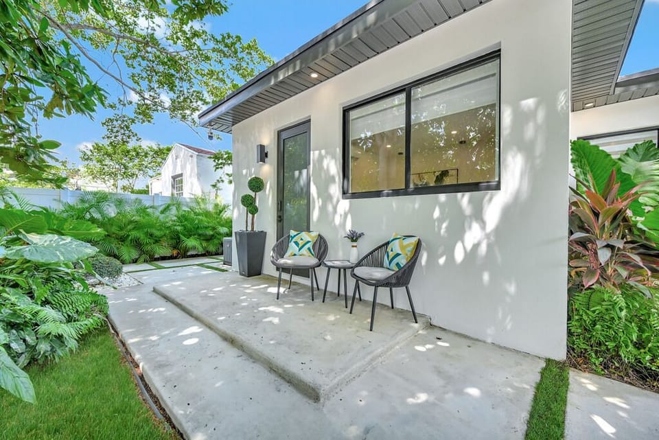 "Modern patio retreat surrounded by lush greenery and natural light."