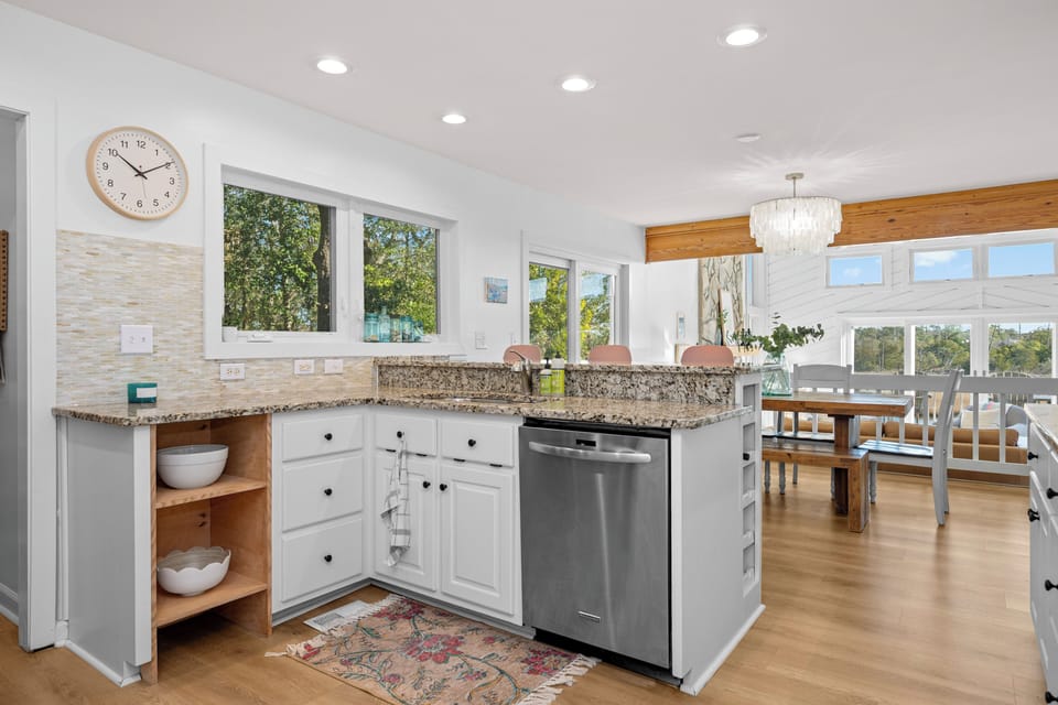 Cook with ease in your gourmet kitchen featuring granite counters, stainless appliances, and open shelving for your vacation essentials.