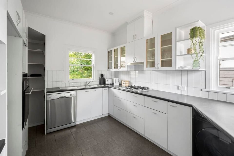 Functional full kitchen with ample bench space and everything needed for home cooking.
