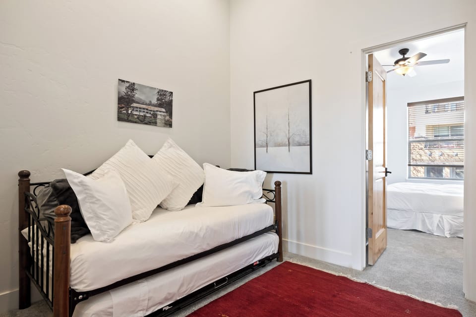 - Twin daybed with pull-out trundle option  
- Soft linens and accent artwork nearby  
- Great space for kids or extra sleepers