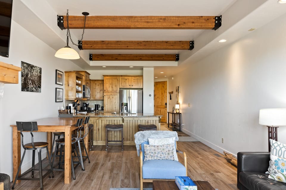 - Open layout with rustic wood beam ceiling  
- Comfortable seating for family gatherings  
- Dining area flows into kitchen and lounge