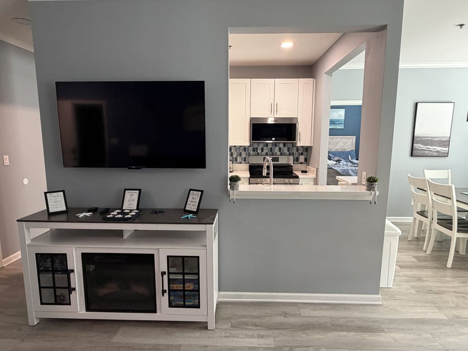 Sleek living room with smart TV and pass-through to updated kitchen