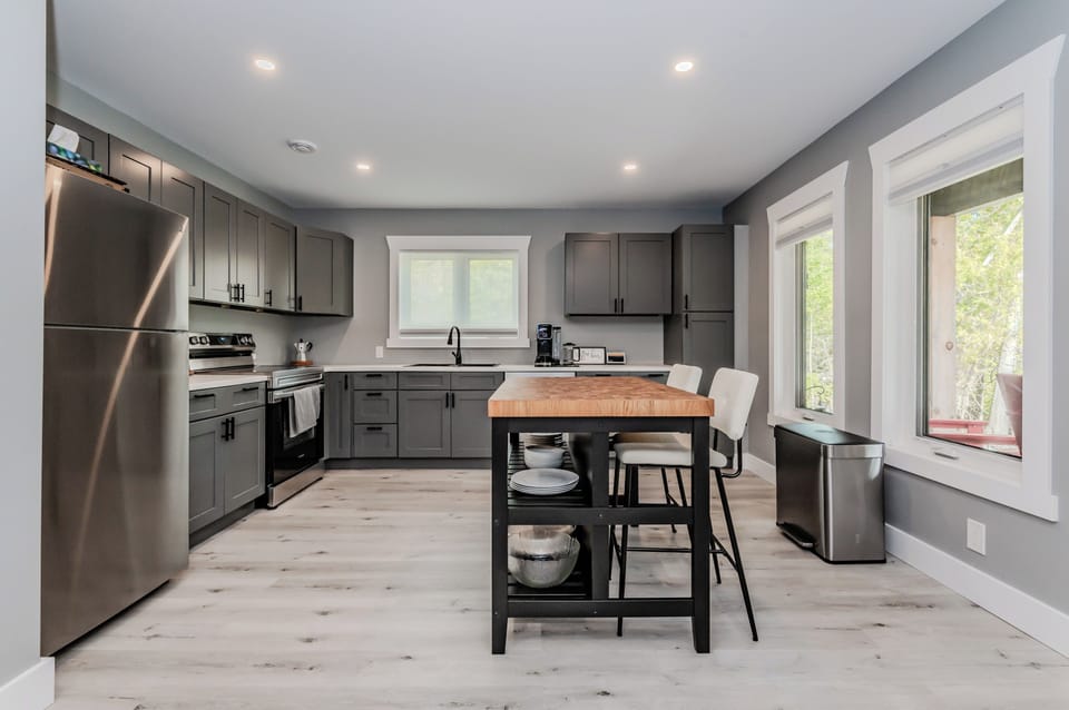 The sleek, modern kitchen is fully equipped with stainless steel appliances, ample counter space, and everything you need to prepare delicious meals during your stay.