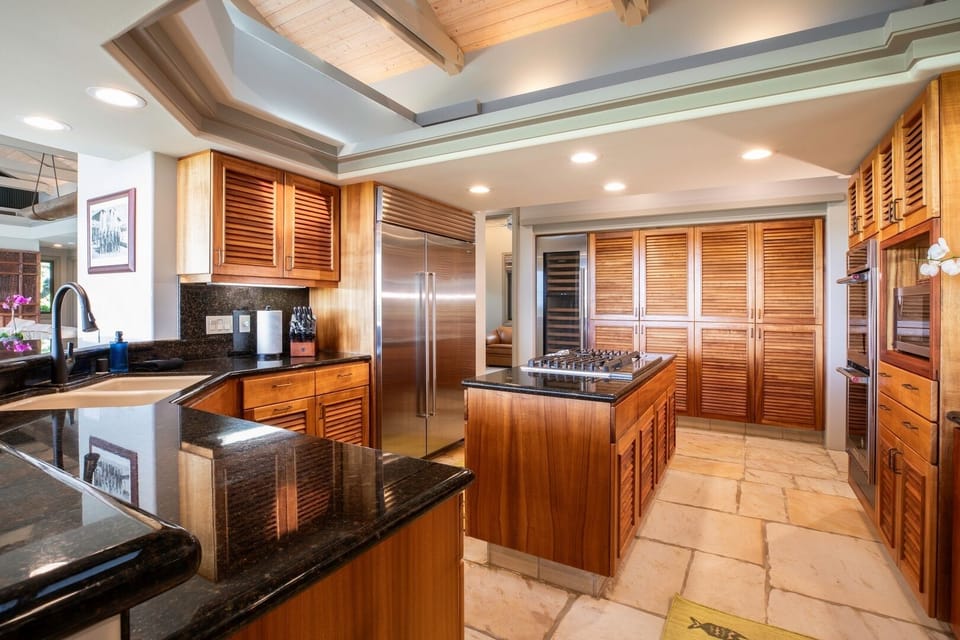 Chef’s kitchen with rich Koa wood cabinetry and high-end appliances — ready for gourmet meals or casual breakfasts.