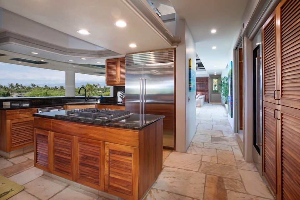 Sleek kitchen with Sub-Zero fridge, wine cooler, and double ovens — everything you need for elevated island cooking.