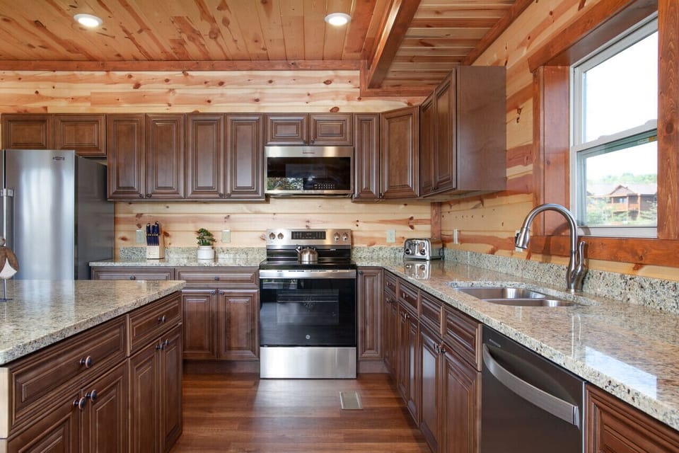 Fully equipped modern kitchen with granite countertops and rustic cabin charm