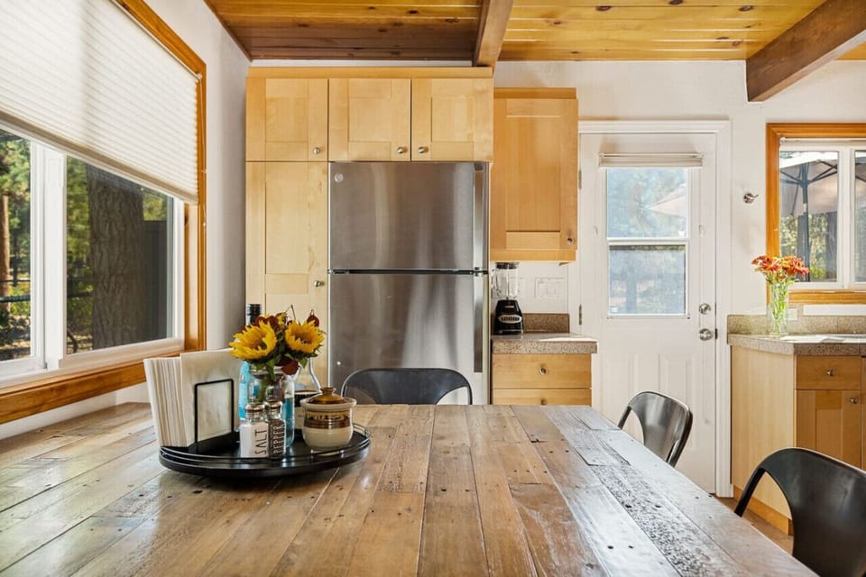 An open-concept kitchen with a wooden dining room table.