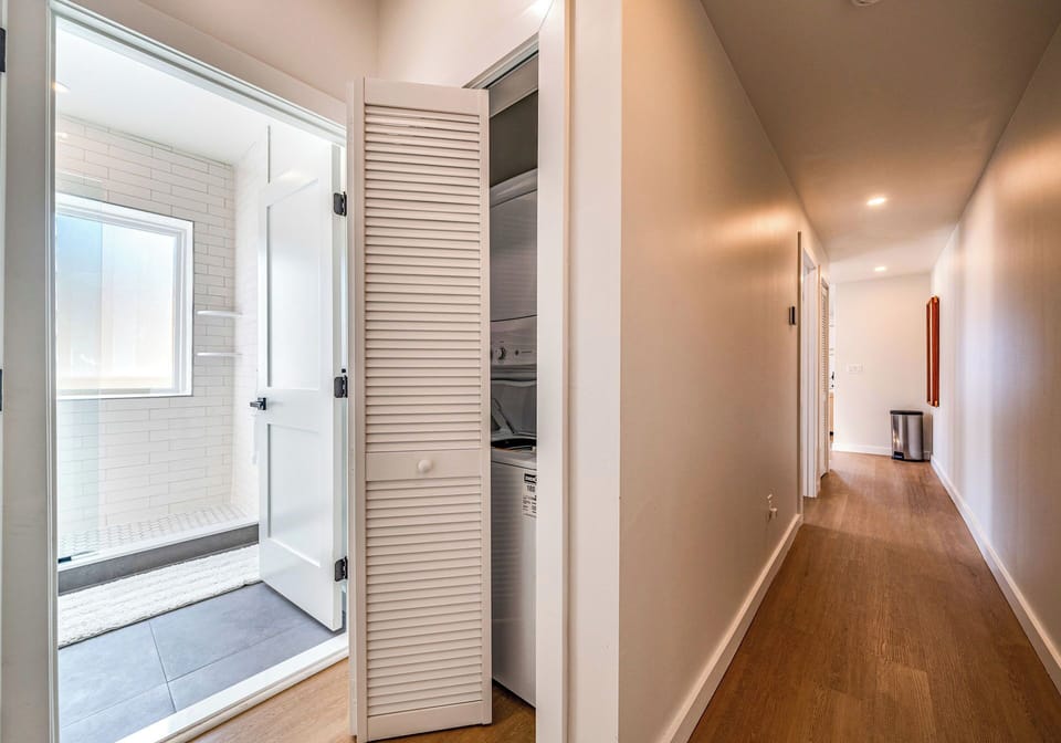 Convenient hallway with laundry facilities and access to a modern bathroom