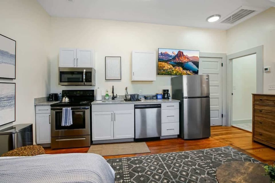 Modern kitchen setup w/ stainless appliances & ample counter space for cooking at home