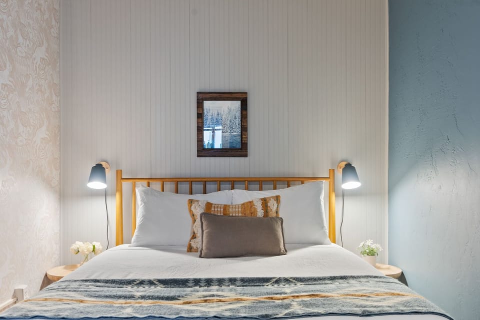 Cozy, well-styled bedroom with reading lamps and plush bedding