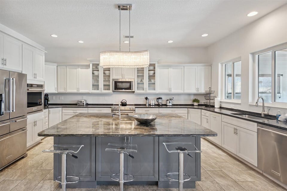 Bright gourmet kitchen with sleek finishes and a grand island.