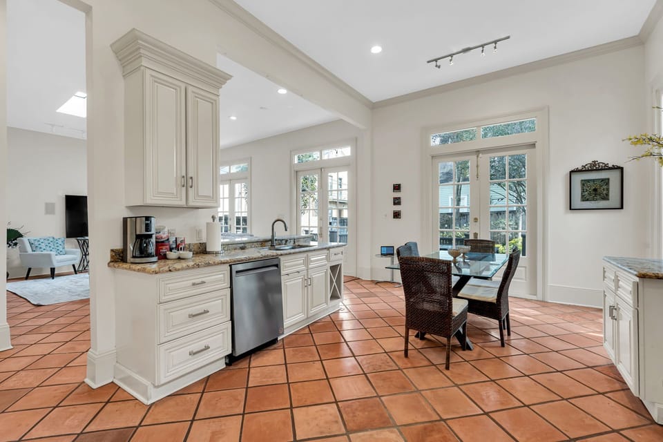 Sun-drenched kitchen & dining area w/ classic terracotta floors & timeless charm.
