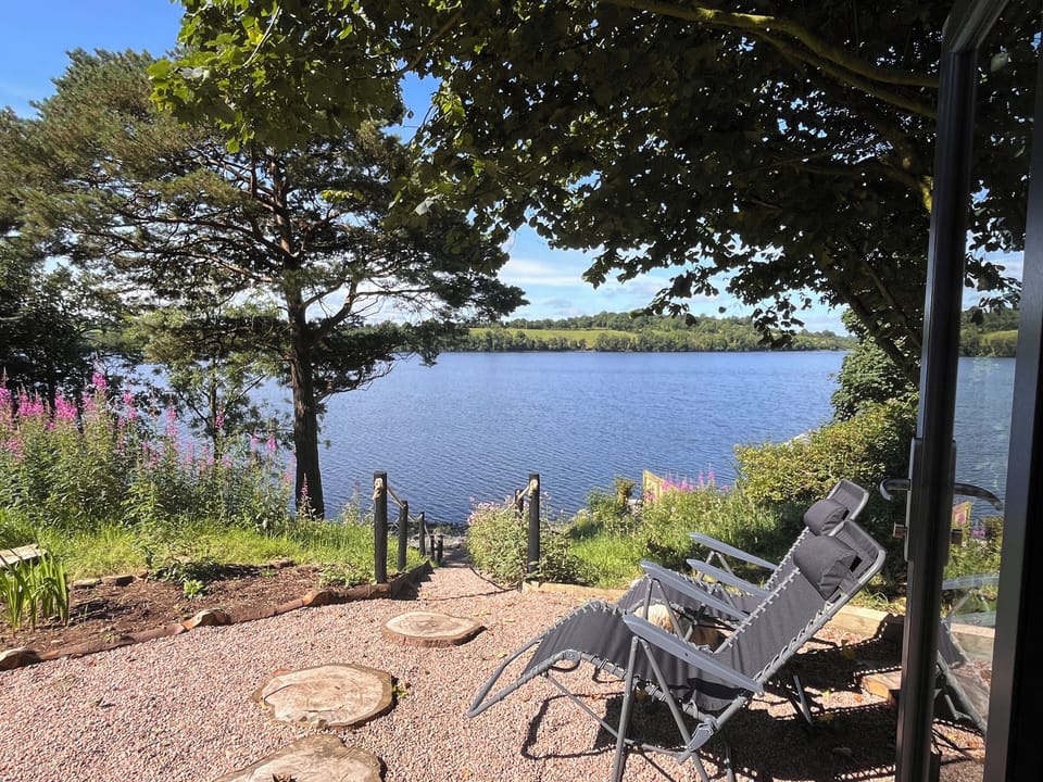 Loungers outside the relaxation room beside the steps down to the lake
