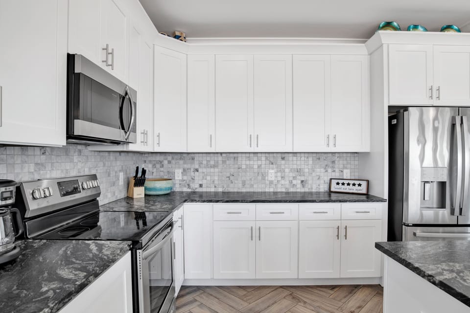 Kitchen has tile backsplash, granite countertops and stainless appliances