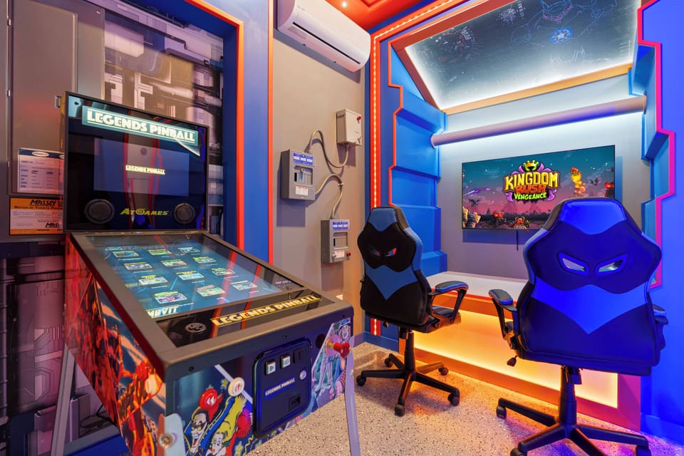 Experience a lively gaming room that blends retro arcade charm with modern design. With a vibrant pinball machine and stylish blue chairs, it's an ideal place for fun and friendly competition, offering endless entertainment in a.