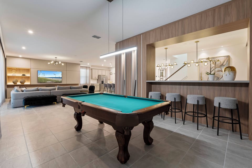 Enjoy our vibrant entertainment area with a classic pool table, warm wood paneling, and modern lighting. It's the perfect spot for friendly games and relaxing in cozy seating while enjoying a welcoming atmosphere.