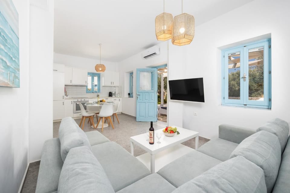 Open-plan living room with sofa, dining area, kitchen, A/C, WiFi internet, and satellite TV
