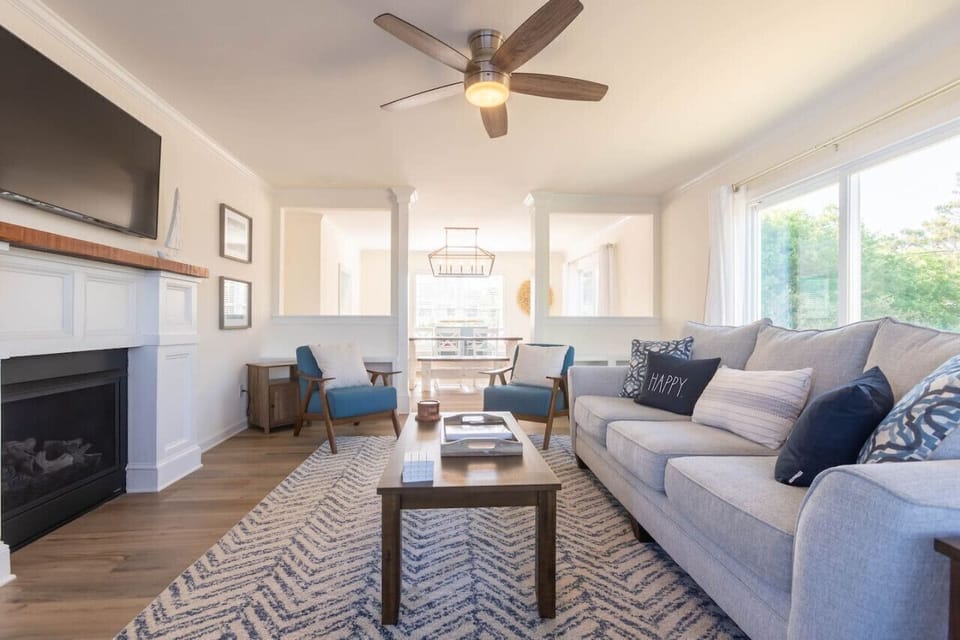 The living room offers comfortable seating, a 55" smart TV for all your streaming needs, access to the wrap-around deck and is just off the dining room.
