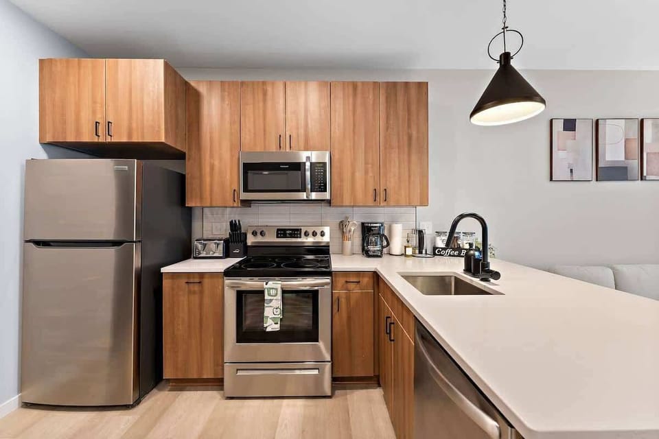 Modern kitchen with stainless steel appliances, wood cabinets, and sleek design