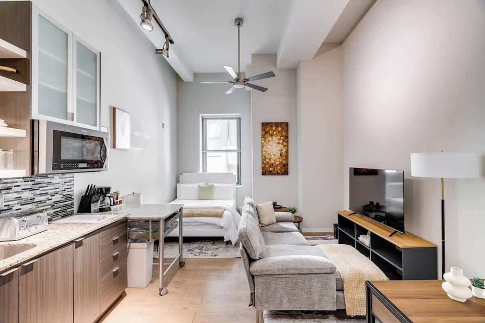 Chic studio with a full kitchen, cozy bed, smart TV, and stylish modern vibes.