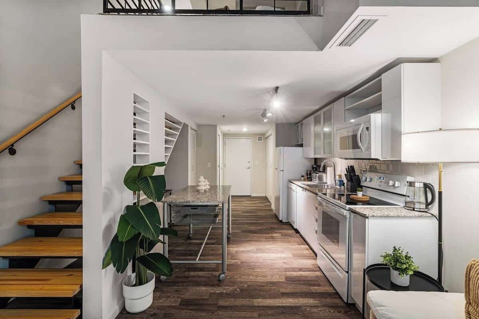 Chic loft kitchen with modern appliances, open layout, and sleek wooden accents.