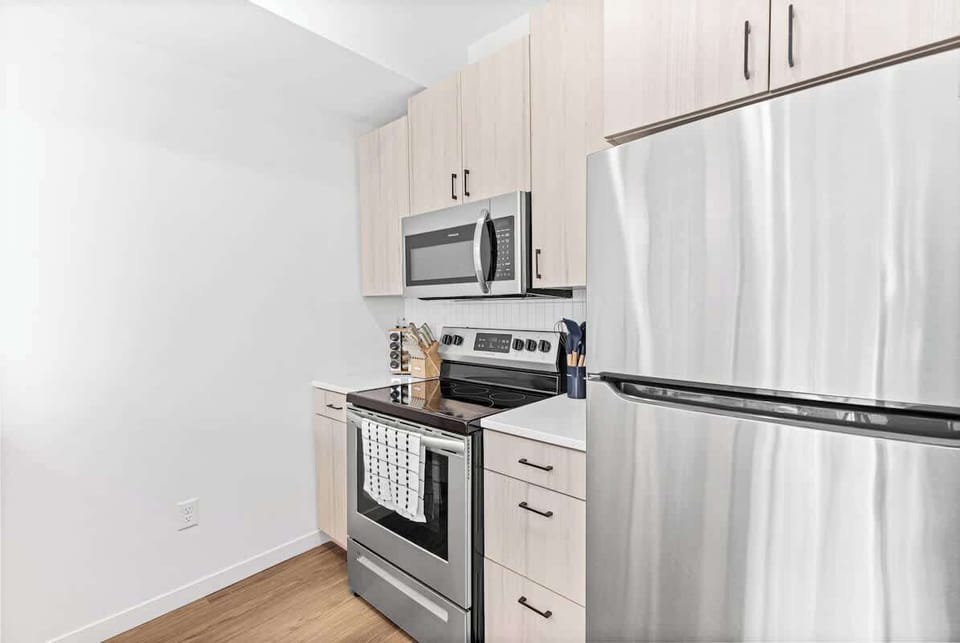 Fully equipped kitchen with dishwasher, microwave, fridge, stove, pots, pans, plates, dishes, cups, coffee maker and many more